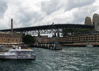 Panorama of the buildings that were once warehouses in Campbell's Cove (The Rocks district) and the Sydney Harbour Bridge (28480796454).jpg