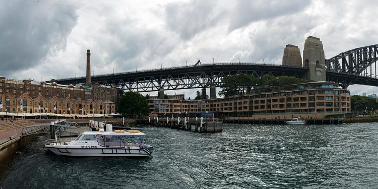 Panorama of the buildings that were once warehouses in Campbell's Cove (The Rocks district) and the Sydney Harbour Bridge (28480796454).jpg