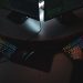 Two people typing on RGB keyboards with code on screens, indicating a cybersecurity environment.