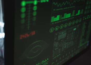 Close-up view of a computer displaying cybersecurity and data protection interfaces in green tones.