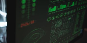 Close-up view of a computer displaying cybersecurity and data protection interfaces in green tones.