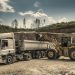 Excavator and truck working together in a quarry, showcasing industrial equipment and operations.