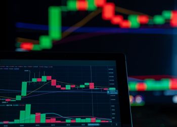 Close-up of a digital trading chart with candlestick patterns and market analysis in a dark setting.