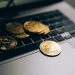 Close-up of golden Bitcoins placed on a laptop keyboard, symbolizing digital currency and modern finance.