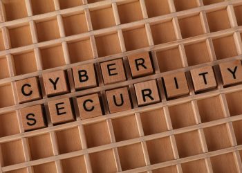 Wooden blocks spelling 'Cyber Security' on a wooden grid background.