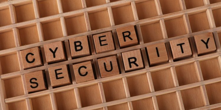 Wooden blocks spelling 'Cyber Security' on a wooden grid background.