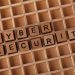 Wooden blocks spelling 'Cyber Security' on a wooden grid background.
